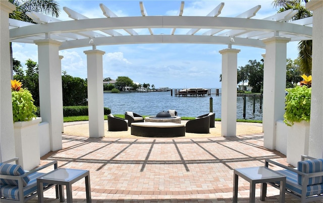 view of patio with a water view and a pergola