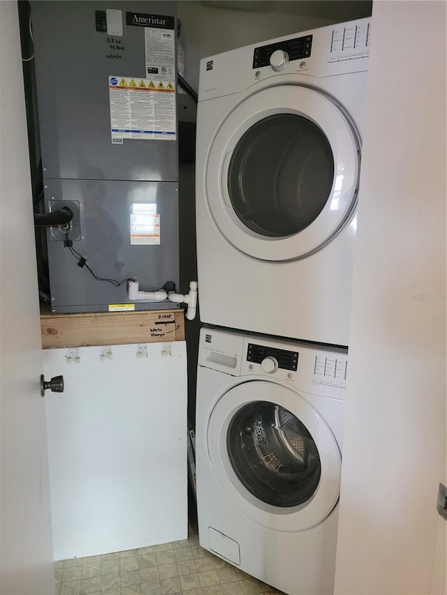 clothes washing area featuring heating unit and stacked washer / drying machine