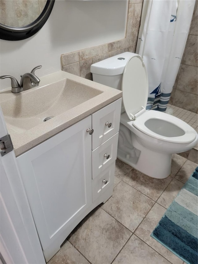 bathroom with curtained shower, tile patterned flooring, vanity, and toilet