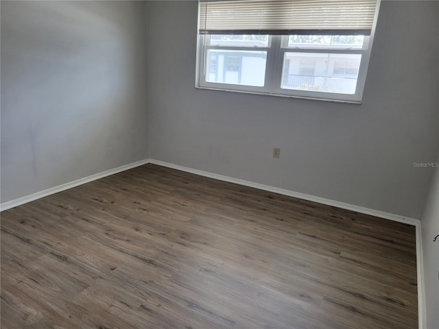 unfurnished room with dark hardwood / wood-style flooring