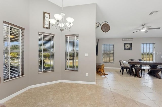 tiled dining space featuring ceiling fan with notable chandelier and plenty of natural light