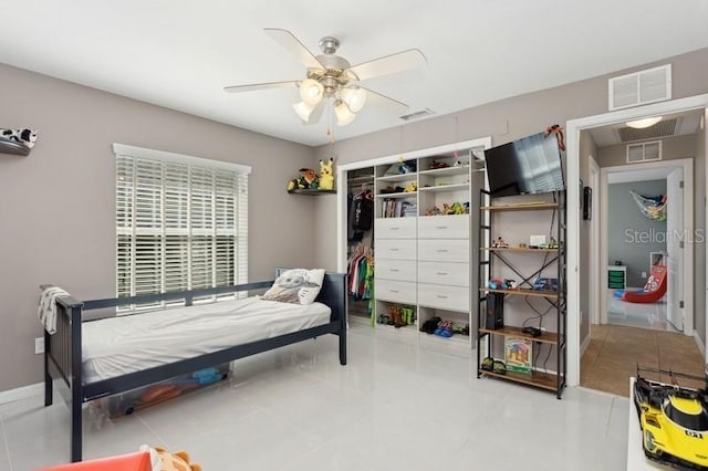 bedroom featuring ceiling fan, light tile patterned floors, and a closet