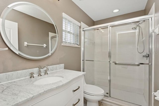 bathroom with tile patterned floors, vanity, toilet, and walk in shower