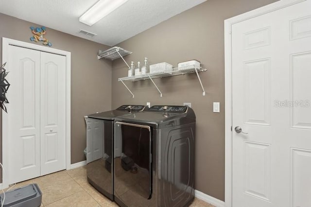 washroom with light tile patterned flooring and washer and dryer