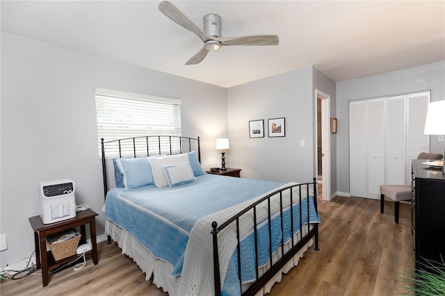 bedroom featuring dark hardwood / wood-style flooring, ceiling fan, and a closet