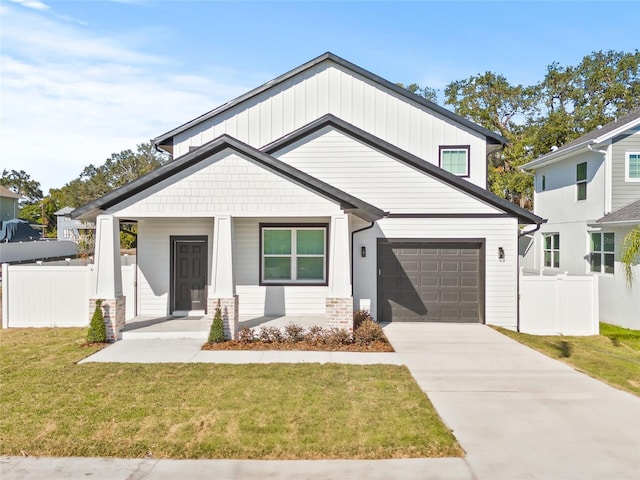 modern farmhouse style home with a front yard, a porch, and a garage