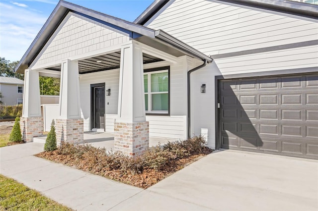 entrance to property featuring a porch and a garage