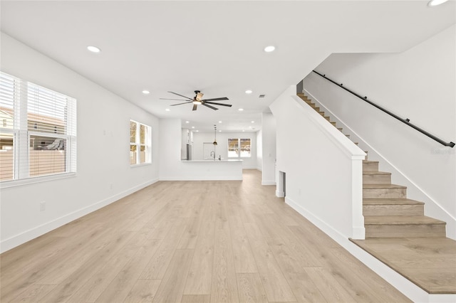 unfurnished living room with light hardwood / wood-style flooring and ceiling fan