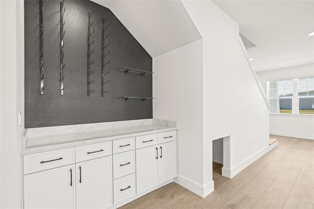 bathroom featuring wood-type flooring and lofted ceiling