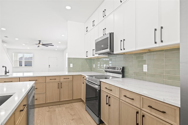 kitchen with appliances with stainless steel finishes, ceiling fan, sink, light hardwood / wood-style floors, and white cabinetry