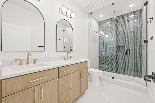 bathroom featuring vanity, toilet, and a shower with door