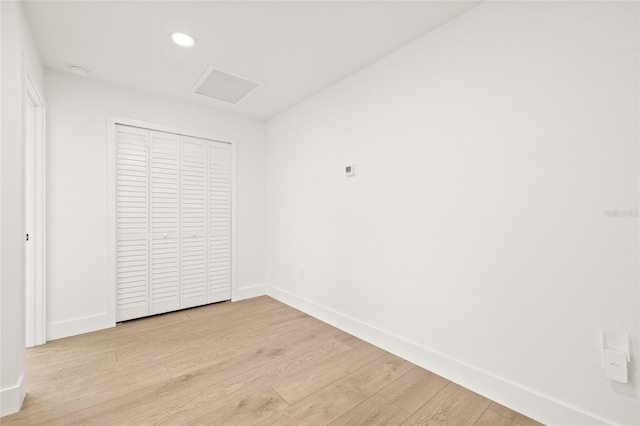 unfurnished bedroom featuring light hardwood / wood-style floors and a closet