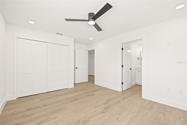 unfurnished bedroom with ceiling fan, a closet, ensuite bathroom, and light wood-type flooring