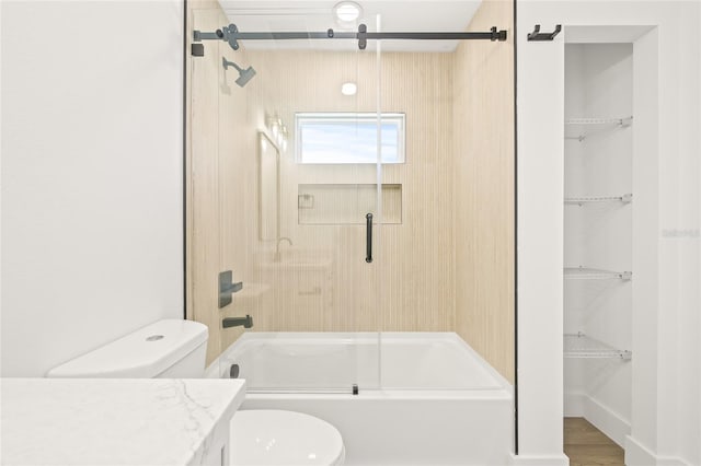 full bathroom featuring hardwood / wood-style floors, vanity, bath / shower combo with glass door, and toilet