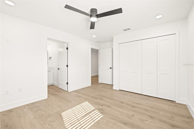 unfurnished bedroom featuring a closet, light hardwood / wood-style floors, and ceiling fan