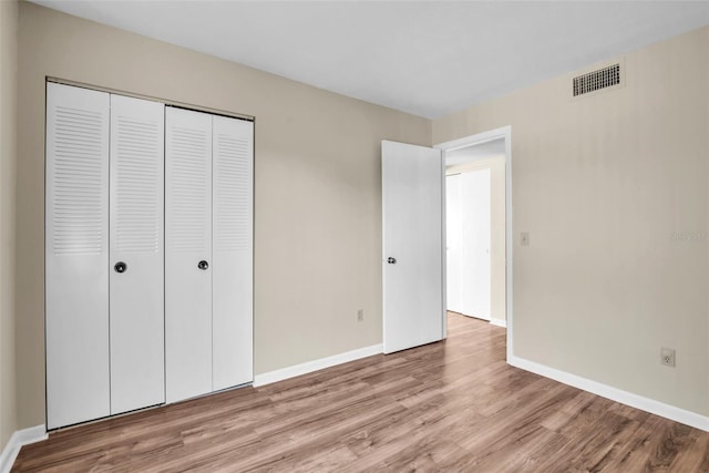 unfurnished bedroom with light hardwood / wood-style floors and a closet