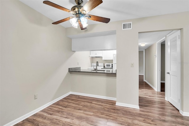 unfurnished living room featuring ceiling fan and hardwood / wood-style flooring