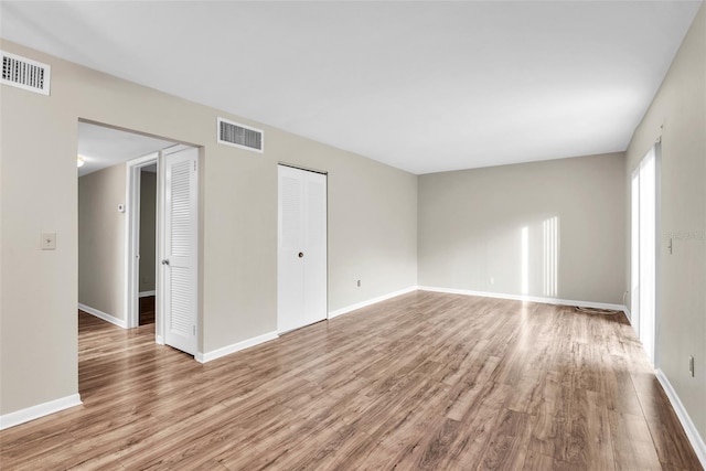 empty room with light hardwood / wood-style flooring