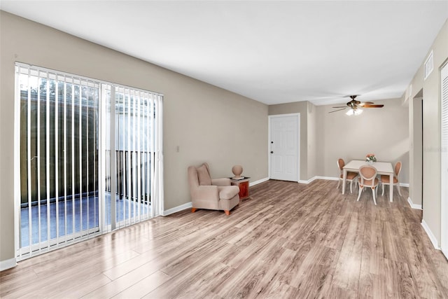 living area with ceiling fan and light hardwood / wood-style floors