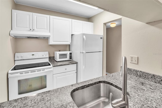 kitchen with white cabinets, white appliances, light stone countertops, and sink