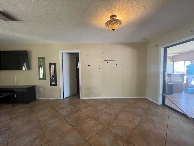 tiled spare room with a textured ceiling