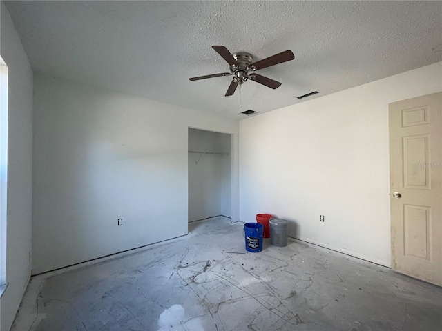 unfurnished bedroom featuring ceiling fan, a textured ceiling, and a closet