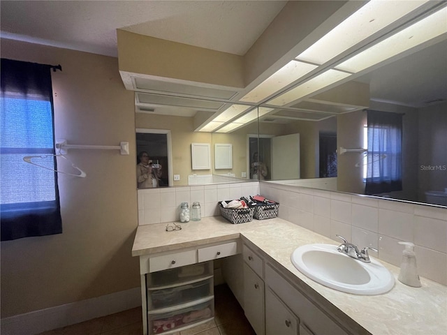 bathroom featuring tasteful backsplash, tile patterned floors, and vanity