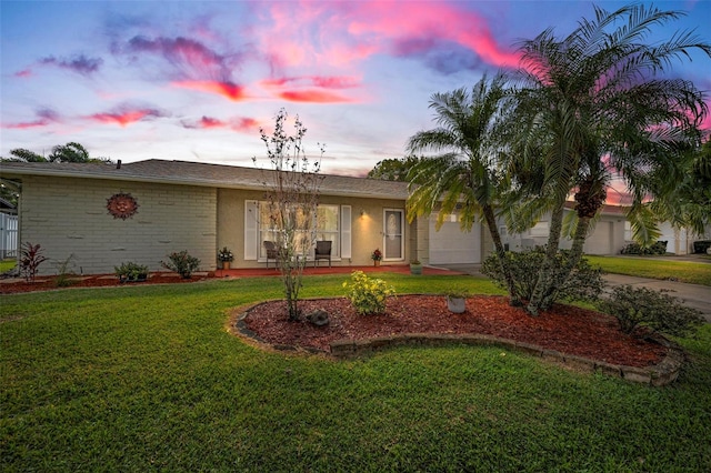 view of front of property with a garage and a lawn