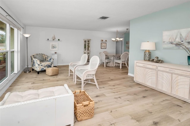 living room featuring an inviting chandelier and light hardwood / wood-style flooring