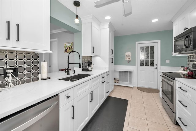 kitchen with white cabinetry, appliances with stainless steel finishes, sink, and hanging light fixtures