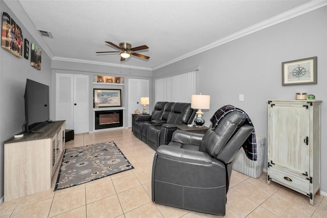 living room featuring ceiling fan, ornamental molding, a textured ceiling, and light tile patterned flooring