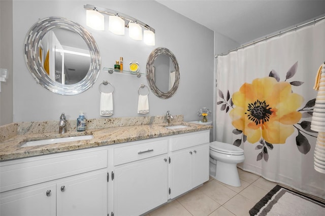 bathroom with tile patterned flooring, vanity, and toilet