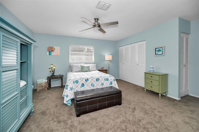 carpeted bedroom featuring multiple closets and ceiling fan