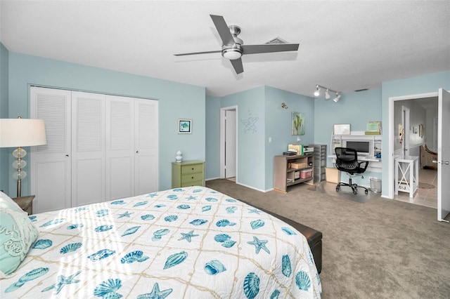 carpeted bedroom with ceiling fan, rail lighting, a closet, and a textured ceiling