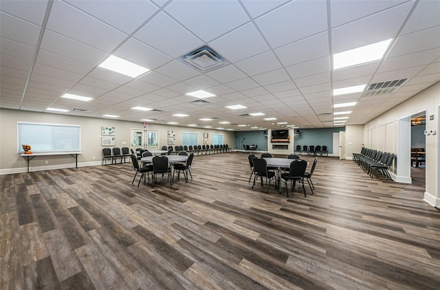 dining area with a drop ceiling and hardwood / wood-style flooring