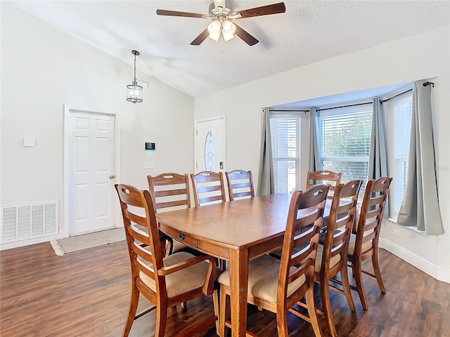 dining space featuring a textured ceiling, ceiling fan, dark hardwood / wood-style flooring, and vaulted ceiling