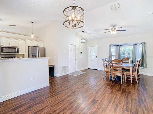 dining room with a textured ceiling, ceiling fan with notable chandelier, dark wood-type flooring, and high vaulted ceiling