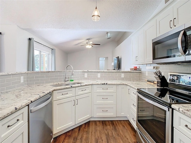 kitchen with decorative backsplash, appliances with stainless steel finishes, white cabinetry, and sink