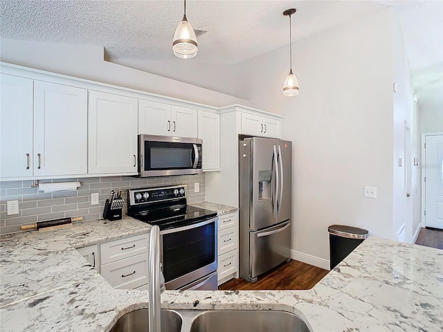 kitchen with white cabinets, hanging light fixtures, appliances with stainless steel finishes, and a textured ceiling