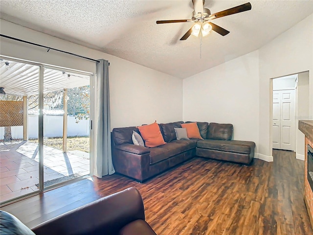 living room featuring a textured ceiling, ceiling fan, and dark wood-type flooring