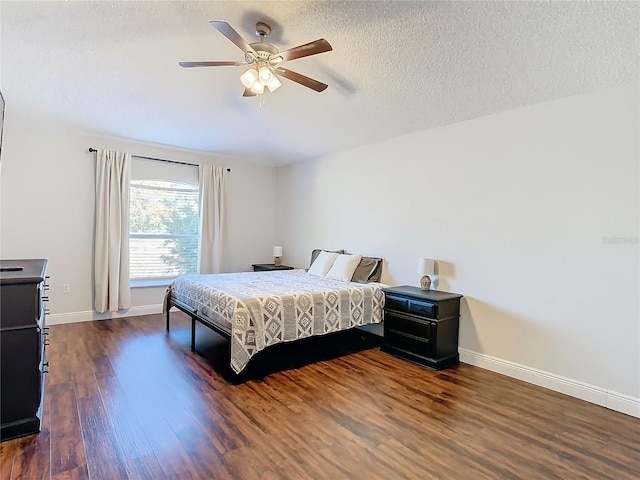 bedroom with ceiling fan, dark hardwood / wood-style flooring, and a textured ceiling