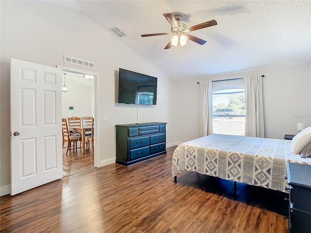 bedroom with a textured ceiling, dark wood-type flooring, ceiling fan, and lofted ceiling