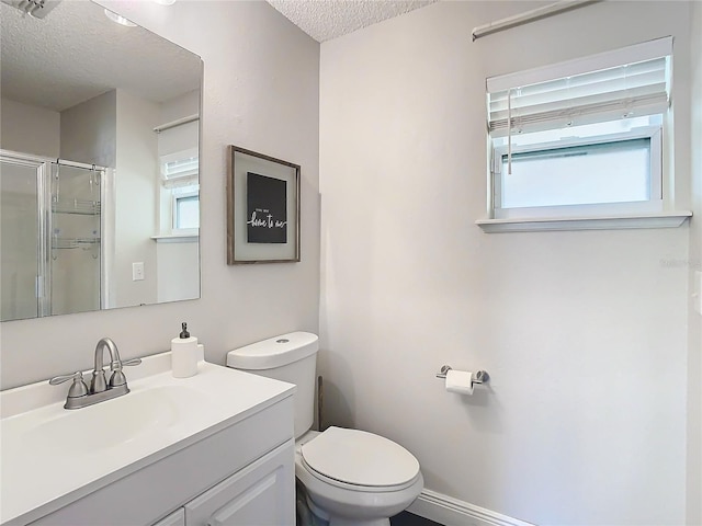 bathroom with vanity, toilet, an enclosed shower, and a textured ceiling