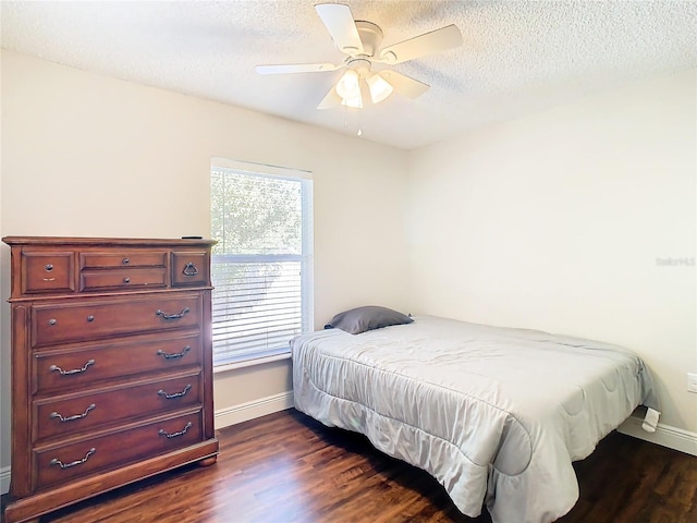 bedroom featuring ceiling fan, dark wood-type flooring, and a textured ceiling