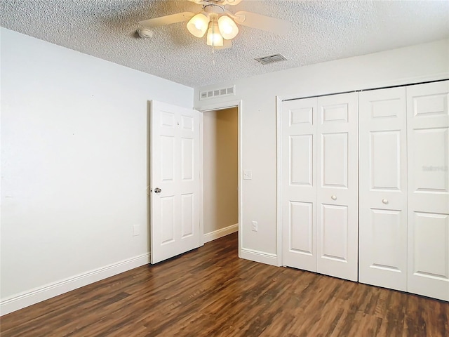 unfurnished bedroom with ceiling fan, dark hardwood / wood-style flooring, and a textured ceiling