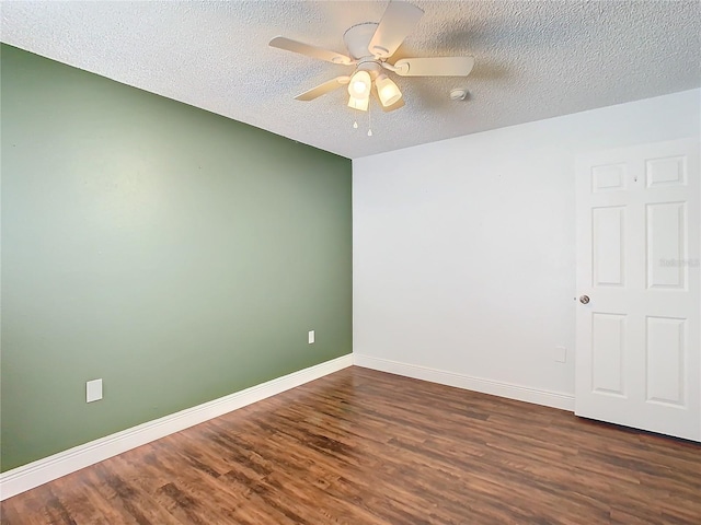 empty room featuring ceiling fan, dark hardwood / wood-style flooring, and a textured ceiling