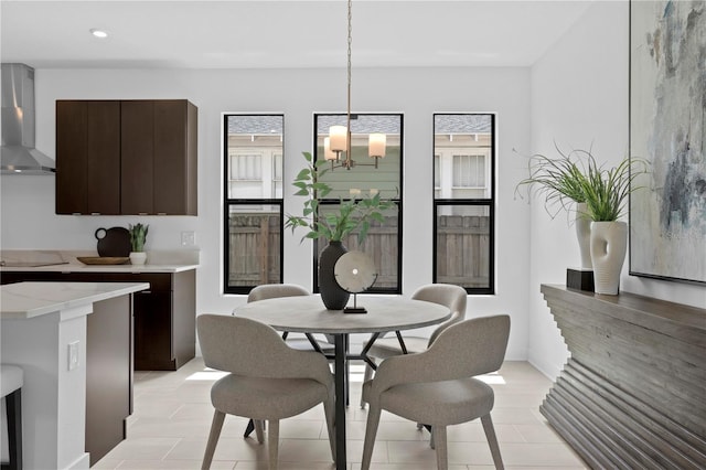 tiled dining room with plenty of natural light and a chandelier