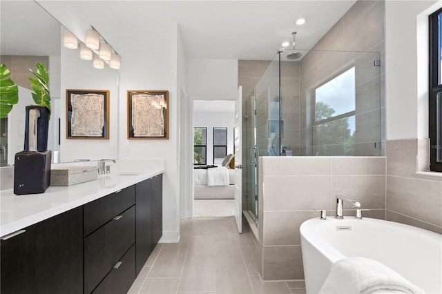 bathroom featuring tile patterned flooring, vanity, tile walls, and plus walk in shower