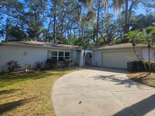 single story home with a garage and a front lawn