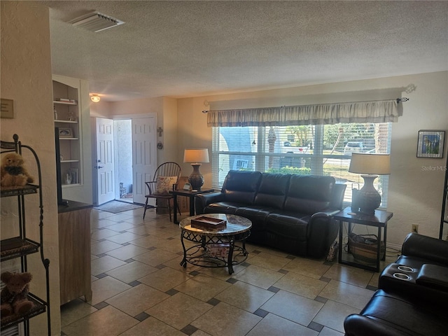 living room with a textured ceiling and built in shelves